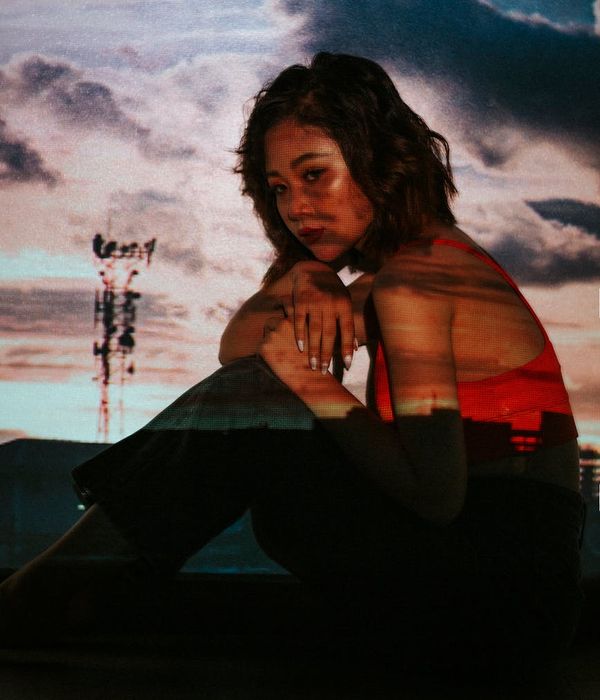 Woman in a dynamic cardio pose against a dark background with amber highlights.